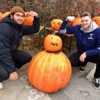 U of t football players with large and small pumpkins